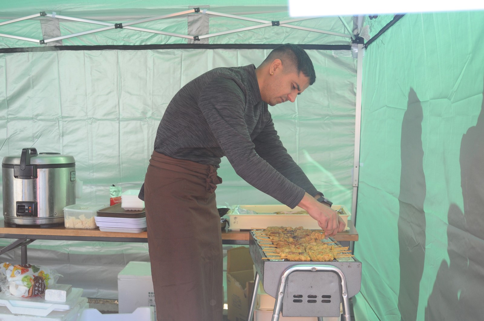 オリエンタル炊き出しの料理の準備をする人