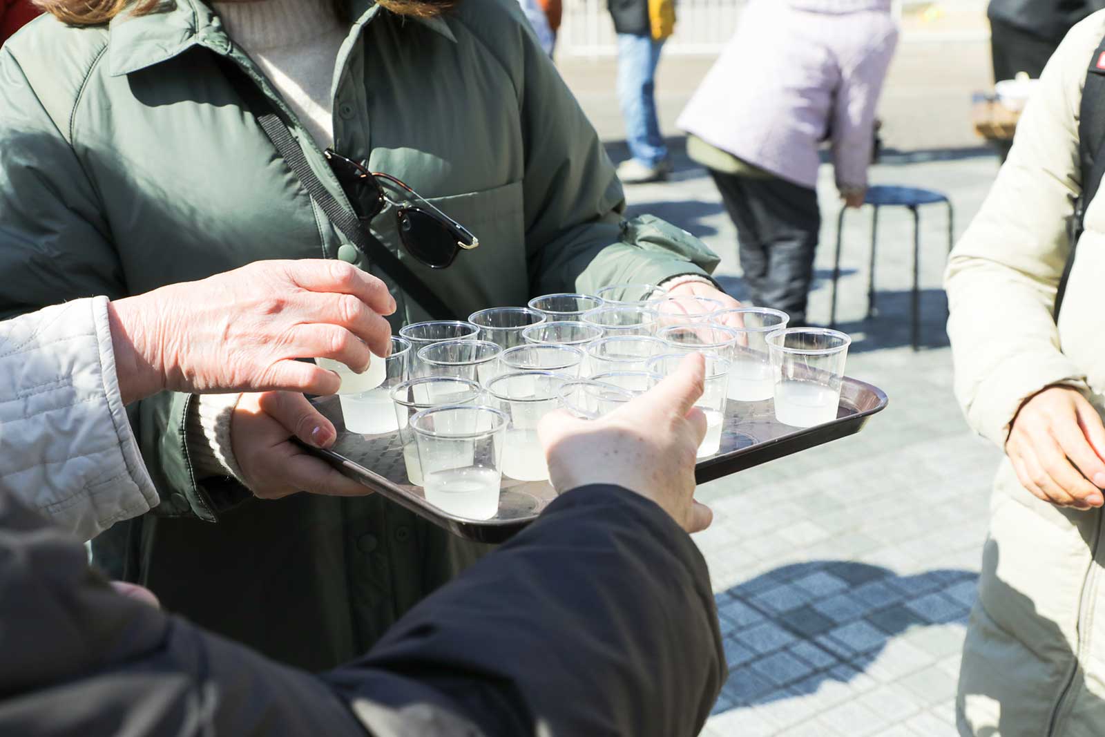 ふるまい酒のクラフトサケに伸びる手