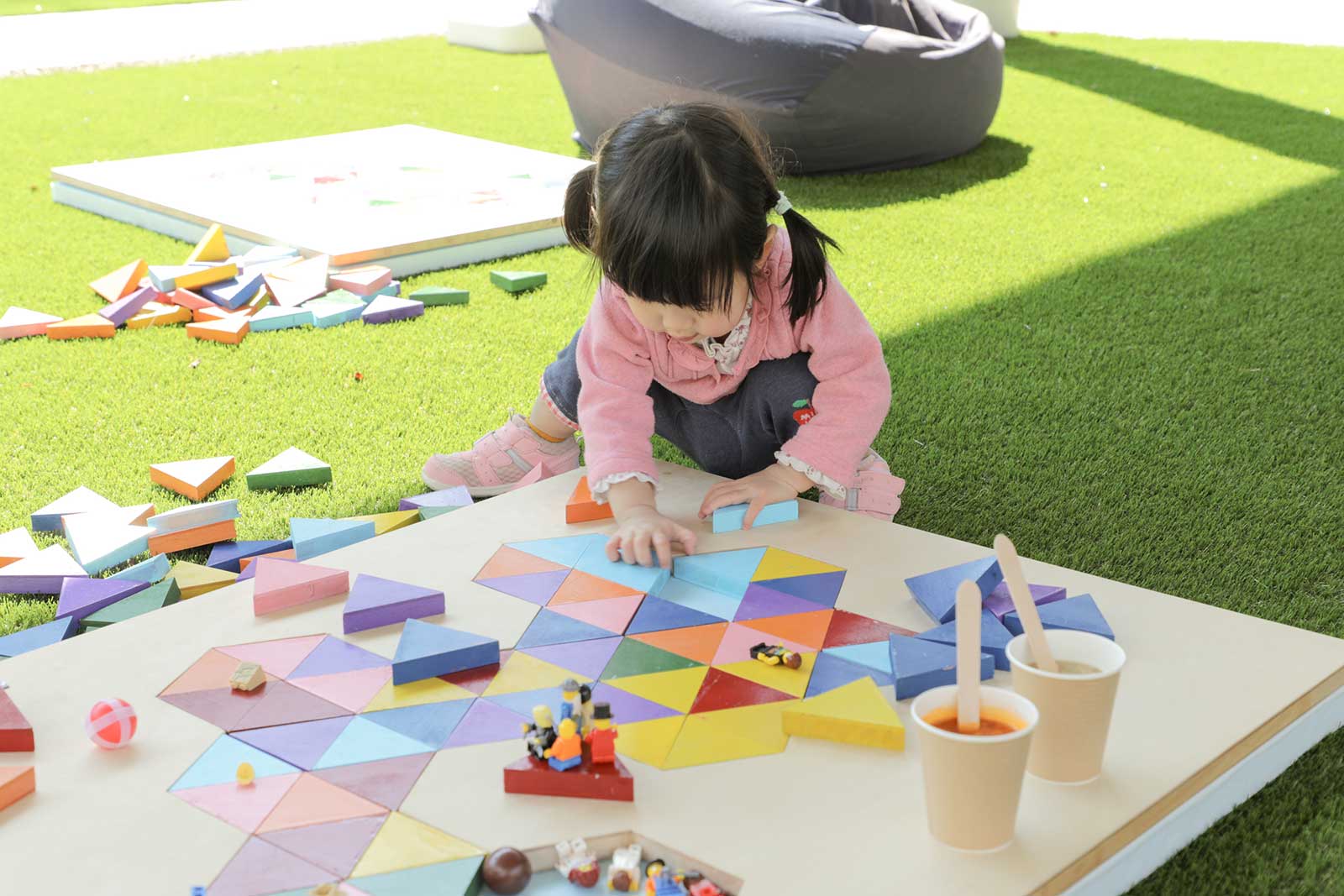 共用部にある人口芝で遊ぶ女の子