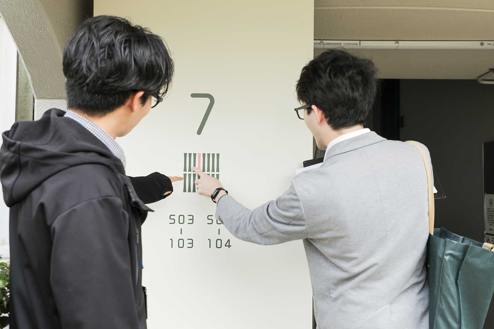 竹の里団地の号棟番号のフォントを確かめる唐澤さんと中川さん