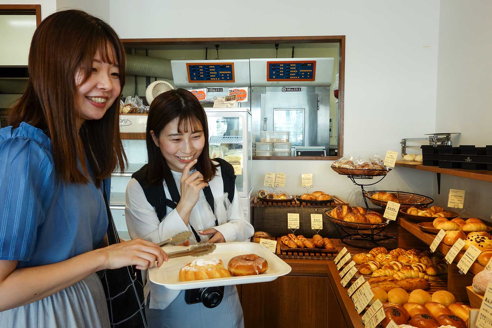 手づくりパンの店maruの店内でパンを選ぶUR職員の二人