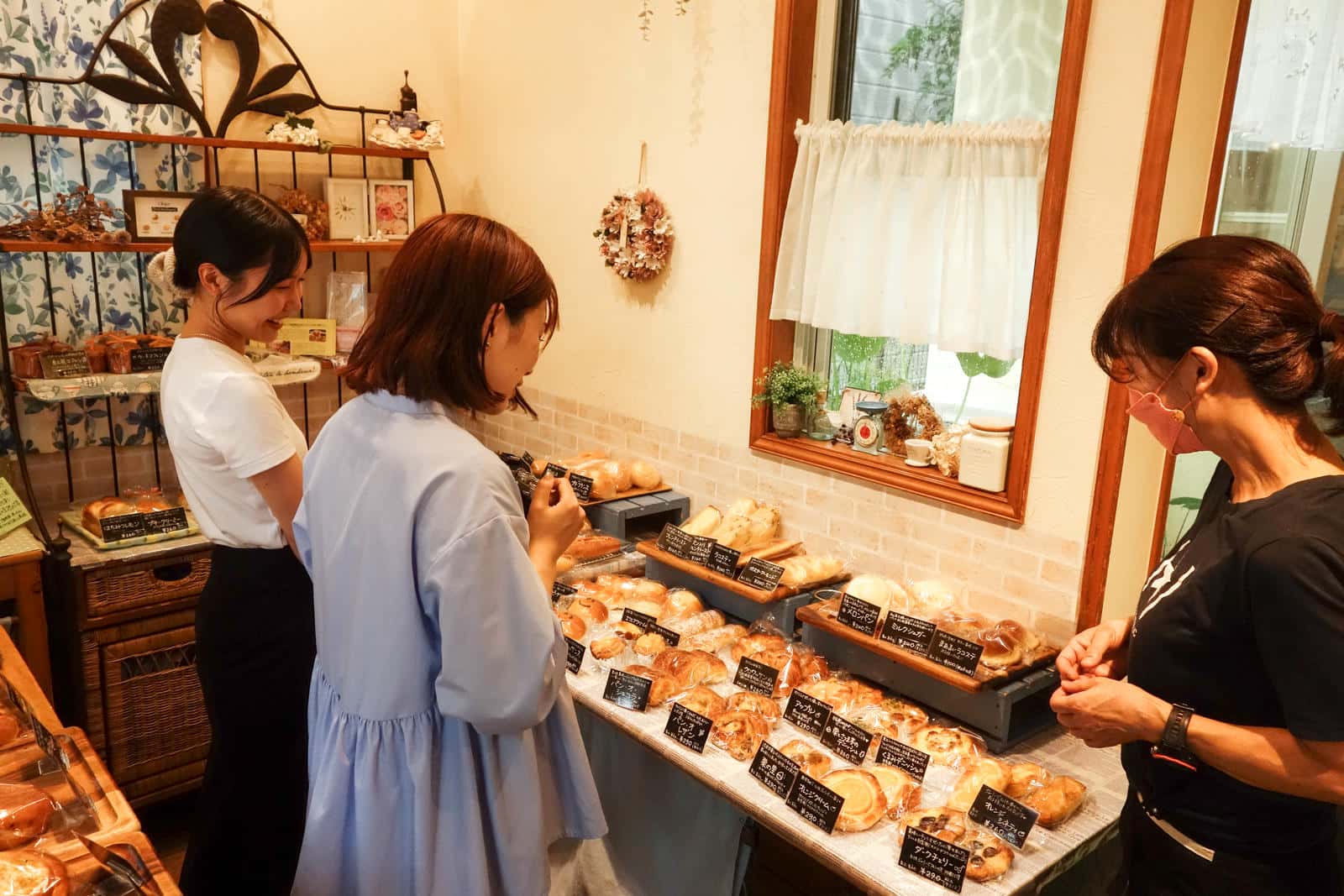 店内でパンを選ぶ2人と店主