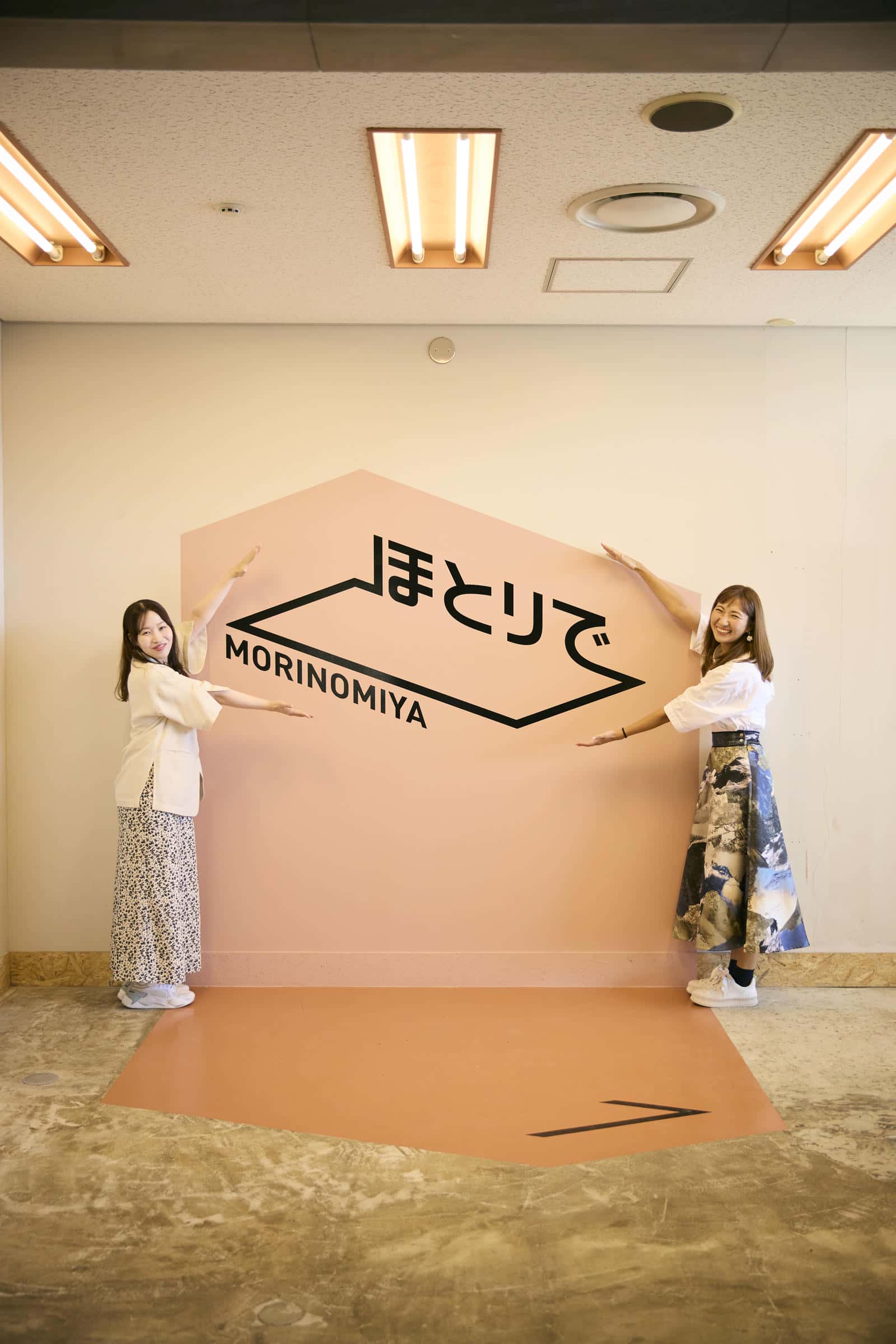 ほとりでの入口にある看板を囲って笑顔の2人