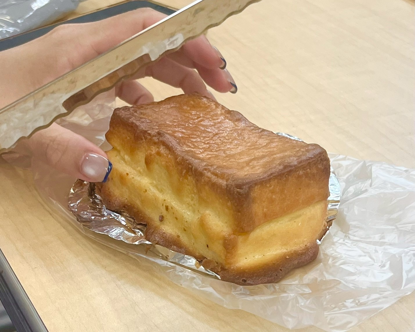 ナポリリーズのパンを包丁で切ろうとしているところ
